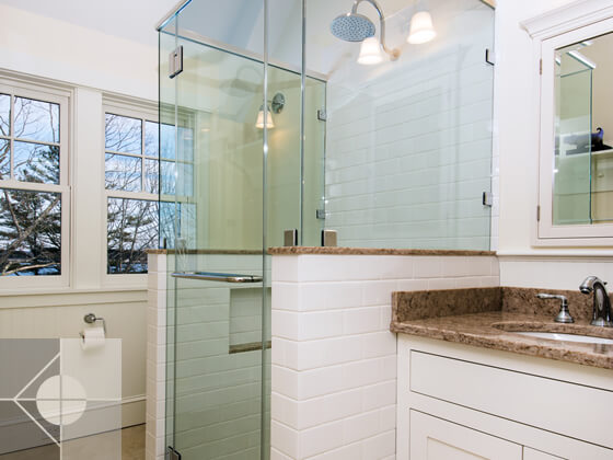 Bathroom counter and sink with walk in shower and outside views.