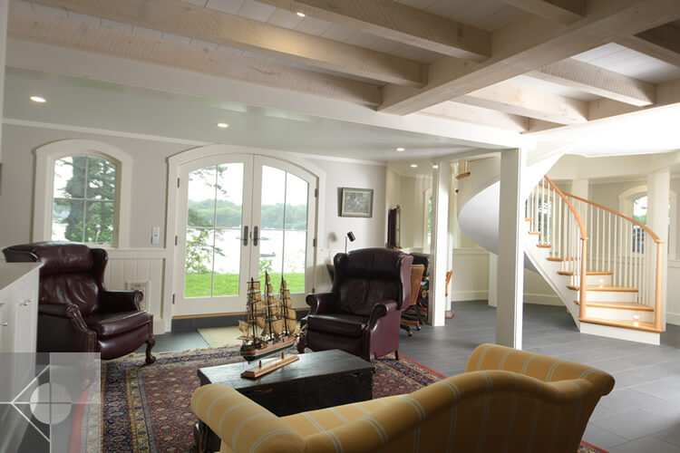 Family room at the base of a spiral staircase with custom designed exterior doors.