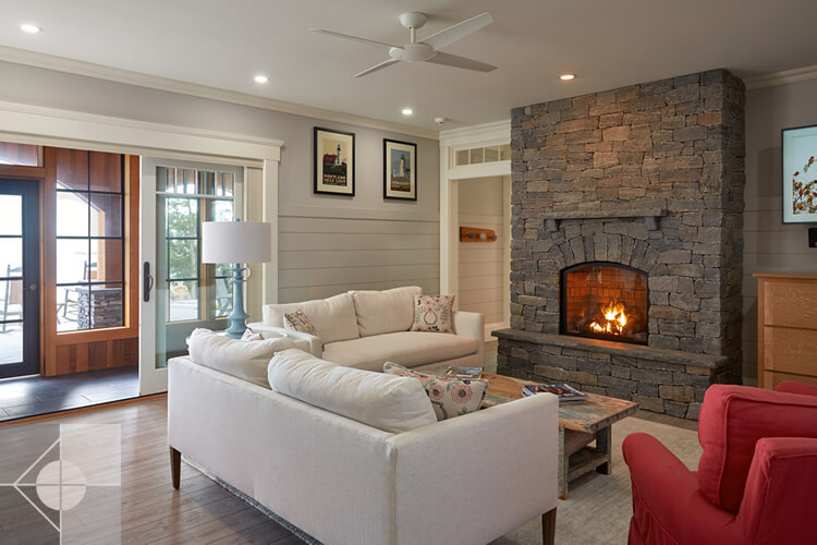 Family room with stone fireplace and doors to the outside.