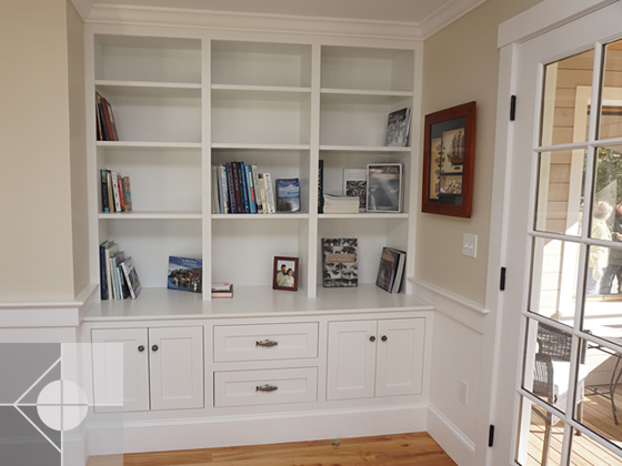 Wall with built in shelving and cupboards.