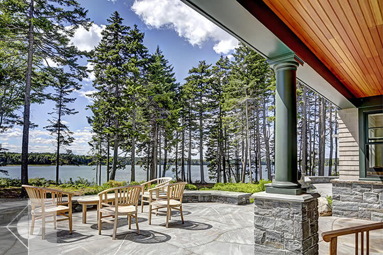 Landscape design featuring a conversation area on the stone terrace with water views.
