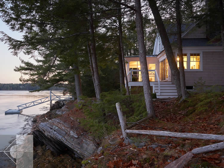 Exterior of the home showing the landscaping of the yard to the dock.