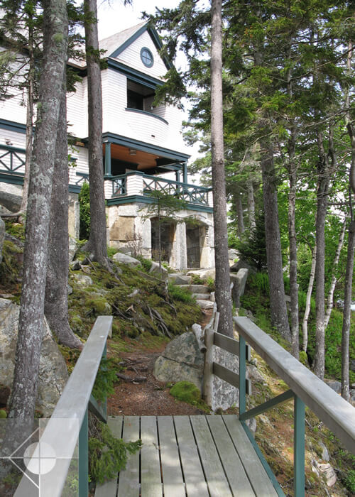 Landscaping design featuing a walking bridge to stone staircase at a Southwest Harbor, Maine home.