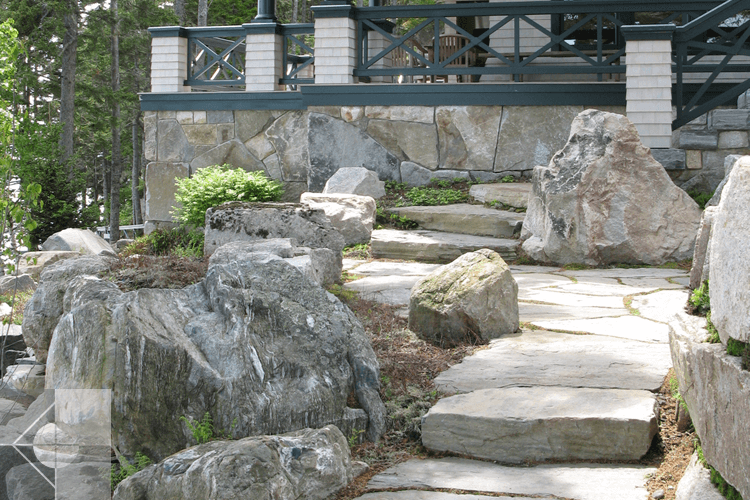 Walkway of stone slabs and deck with veneered stone.
