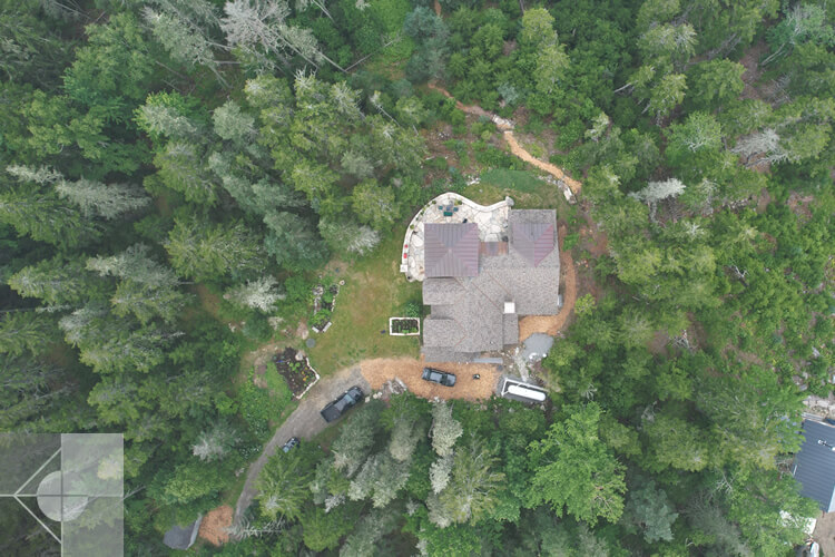 Aerial view of this home showing the roofline and surrounding trees.