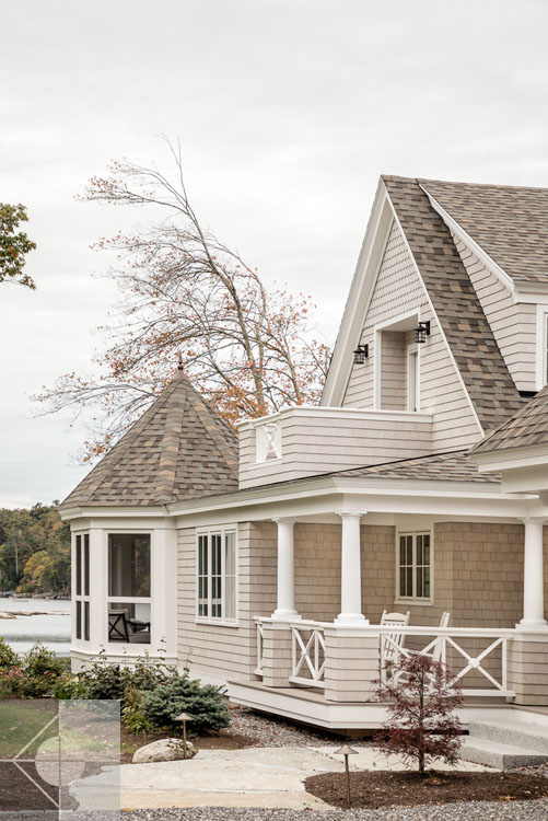 View of Boothbay Harbor home featuring garage and wrap around porch.