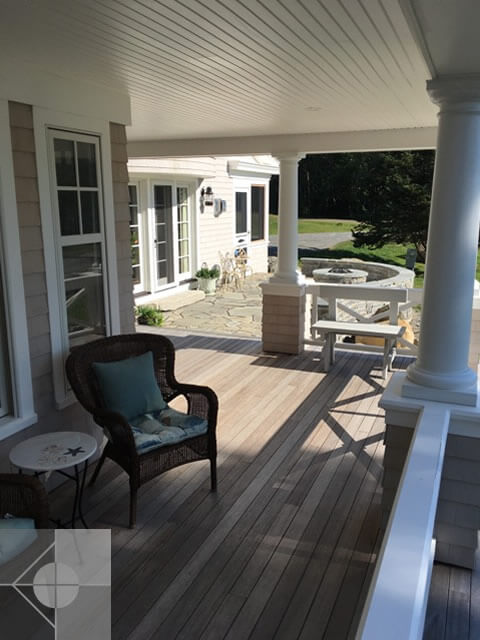 Inside the screened in porch with view of the stone patio and firepit.