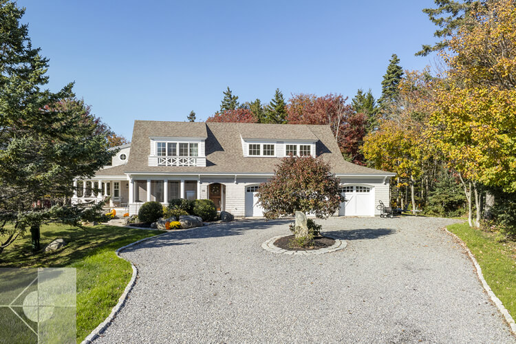 Driveway entrance to this New Harbor home with center of the drivway landscaping.