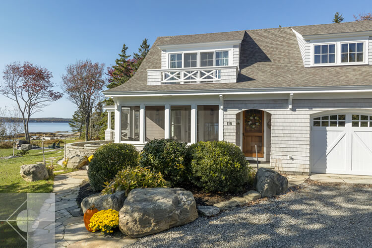Front of house with deck, garagee and landscaping.