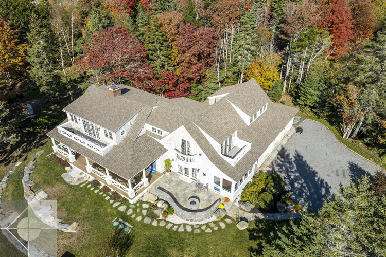 Aerial view of this New Harbor home with fieldstone patio and firepit.